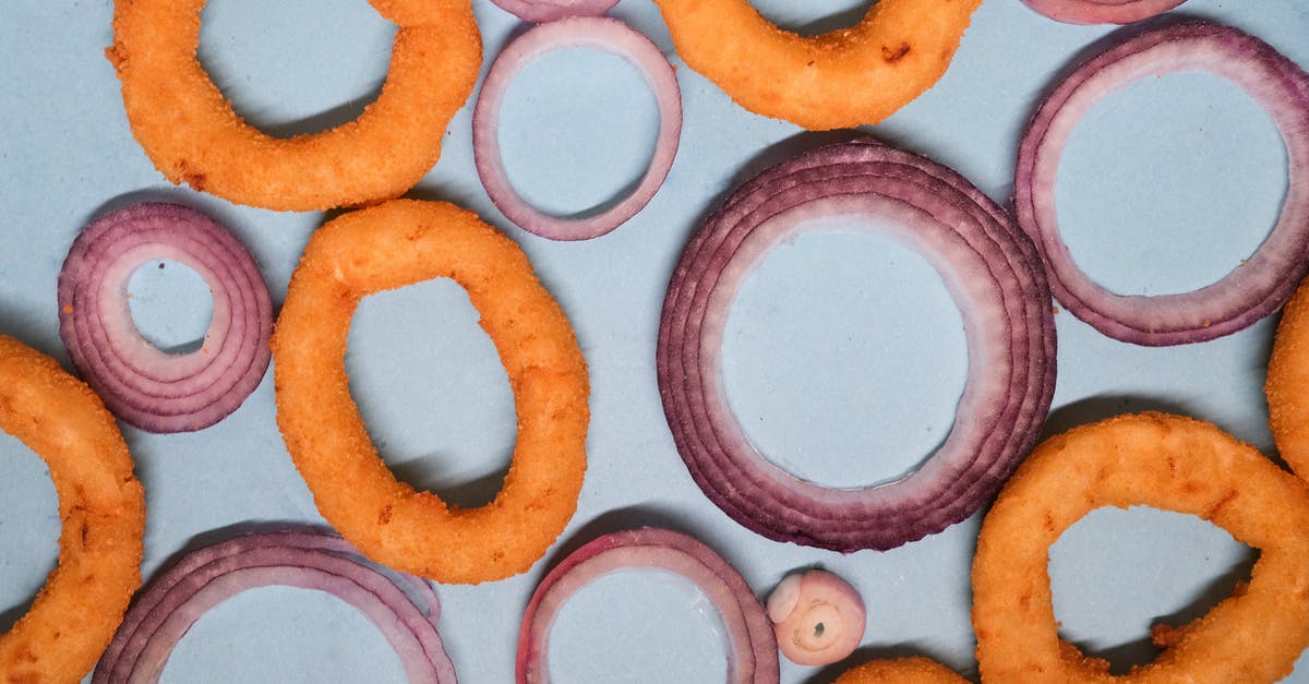 Is it possible to make onion Bhajis without a deep fryer? - Onion rings and sliced onion on blue background