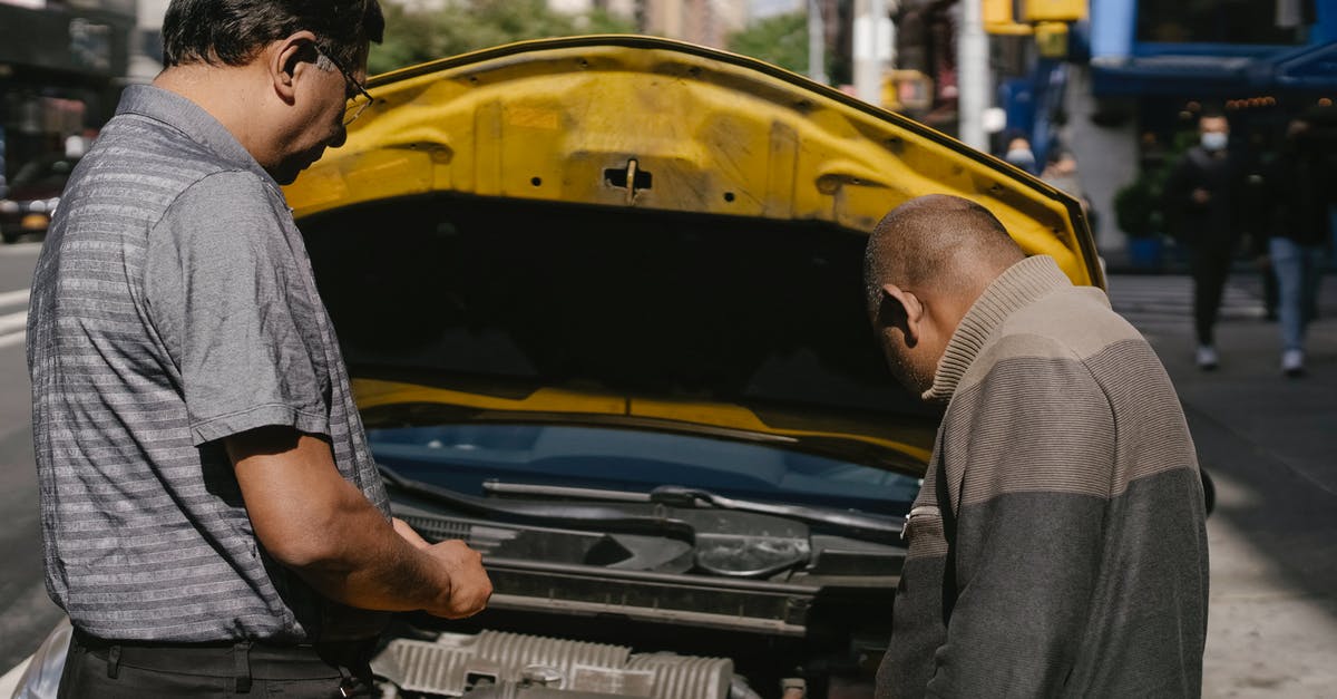 Is it possible to repair damage to the non-stick surface? - Ethnic mechanic checking car standing near man