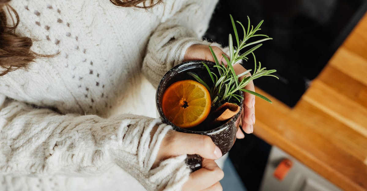 Is it possible/advisable to slice deboned Jamon Iberico on a mandoline? - Woman in White Sweater Holding Black Ceramic Mug With Orange Liquid