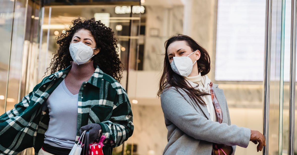 Is it safe to consume microwaved Campbell’s chicken stock? - Low angle of woman with purchases in colorful shopping bags walking through doors of store during coronavirus pandemic