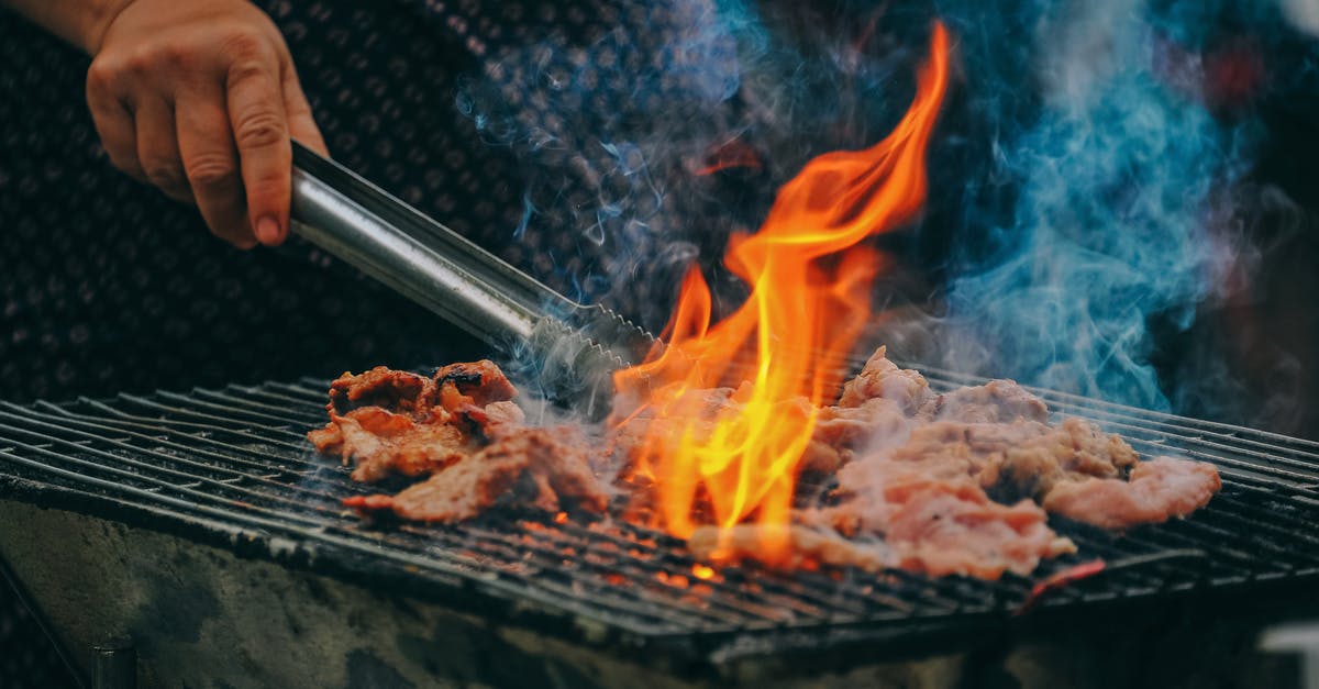 Is it safe to cook in a grill\oven that is rarely cleaned? - Close-Up Photo of Man Cooking Meat