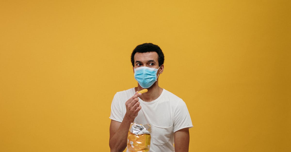 Is it safe to eat mouldy bread? - Man in White Crew Neck T-shirt Eating Chips