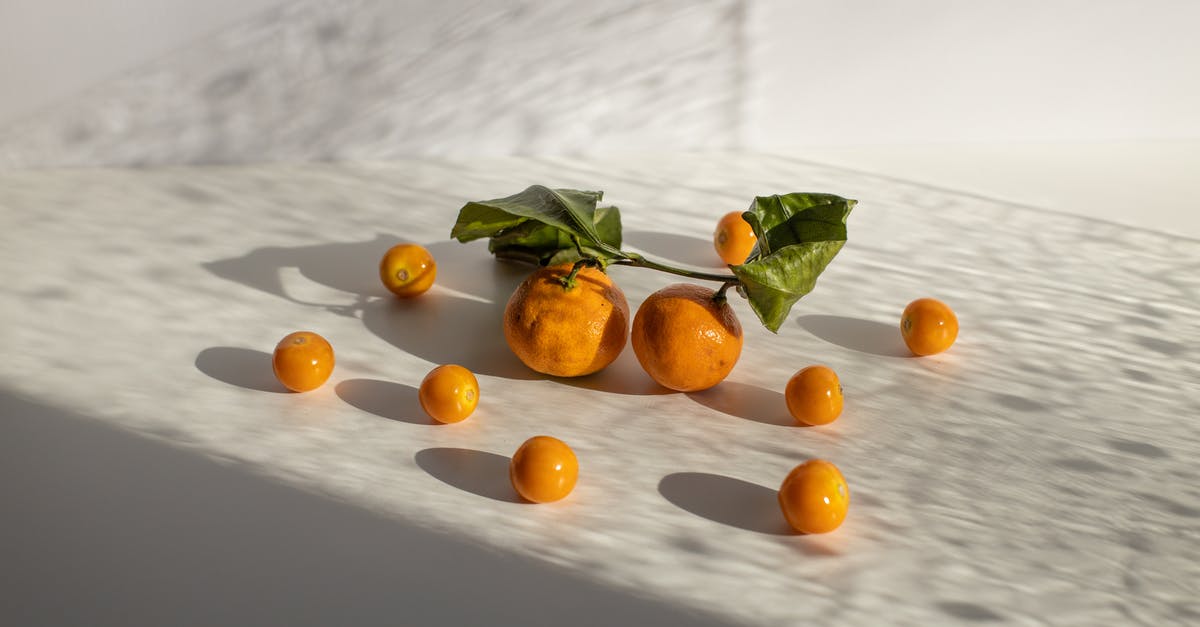 Is it safe to eat raw fish? - Healthy tangerines and groundcherries scattered on white surface in daylight
