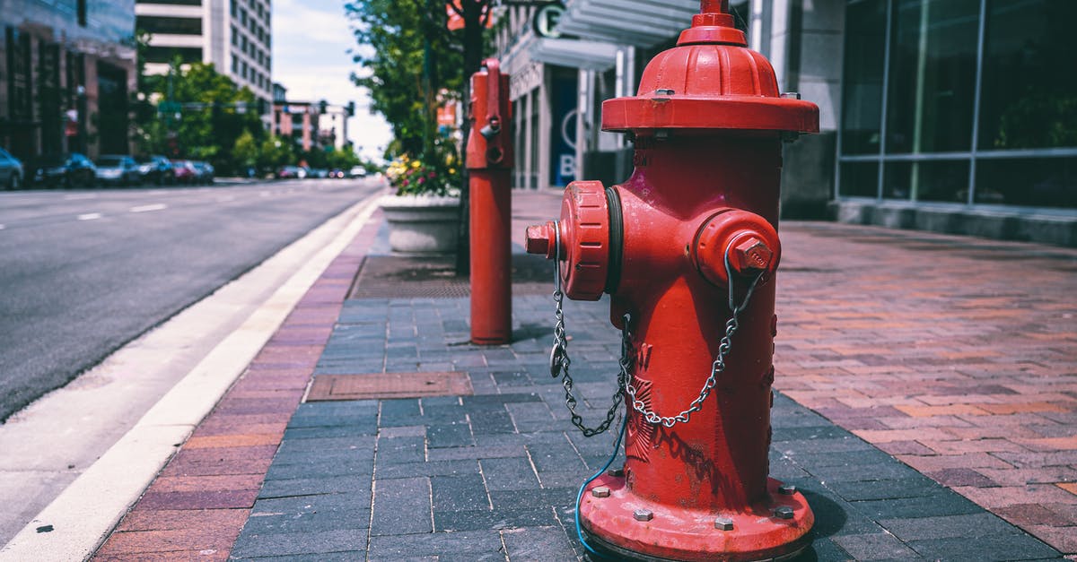 Is it safe to reheat old water in an electric kettle? - Red fire hydrant with chains located on empty street near road and building on sunny day