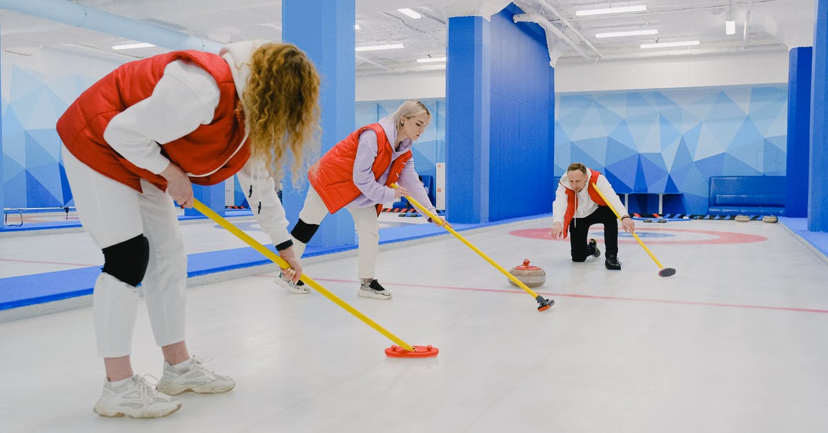 Is it safe to throw frozen meat in marinade? - Full body of sportsman throwing curling stone near sportswomen in activewear sweeping ice sheet with special brooms while playing game