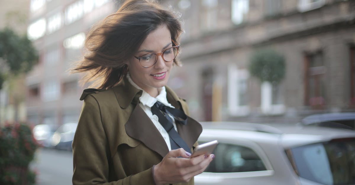 Is it safe to use calphalon when the aanondized coating begins to wear? - Stylish adult female using smartphone on street