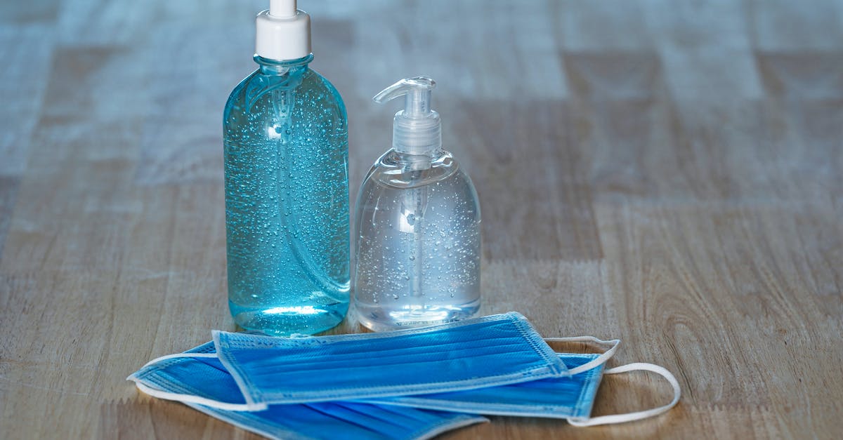 Is liquid seeping from the fish normal when making gravlax? - From above of transparent bottles with bubbled antiseptic liquid soap and gel near medical masks on table