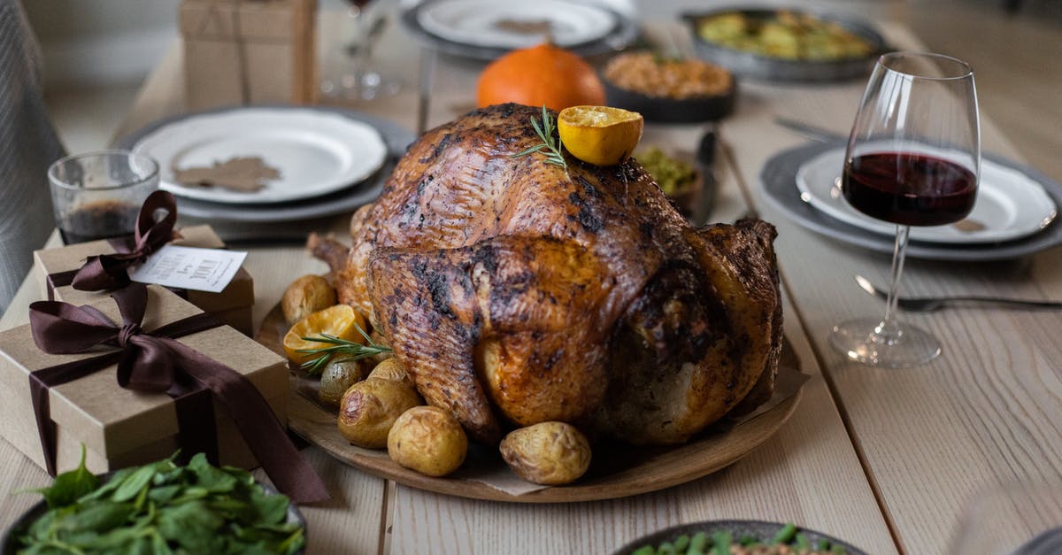 Is the oily liquid from roasting a turkey worth keeping? - High angle of appetizing roasted turkey and glasses of wine with other dishes placed on wooden table prepared for celebrating Thanksgiving Day