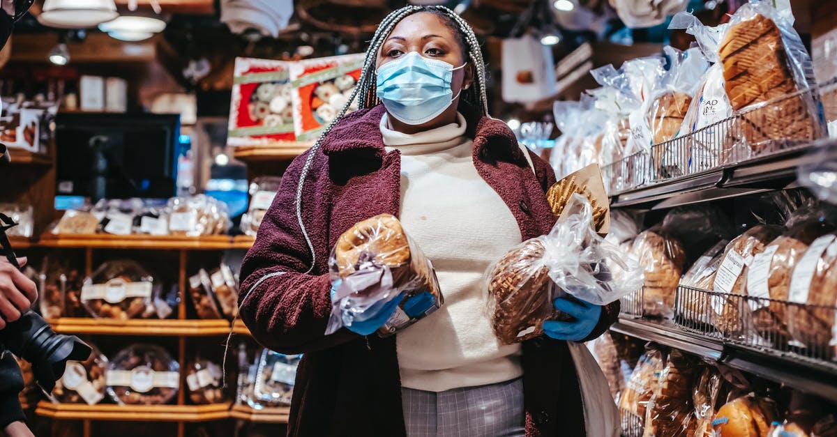 Is the print on eggs safe for consumption? - African American female buyer in protective mask and gloves carrying loafs of bread in grocery store