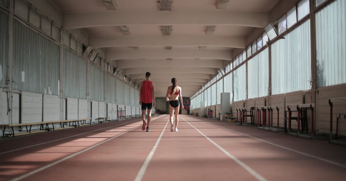 Is there a difference in the taste/seeds of egg-sized eggplants, and long and slim eggplants? - Back view of sportsman and sportswoman in activewear walking along running track in athletics arena during warming up before training
