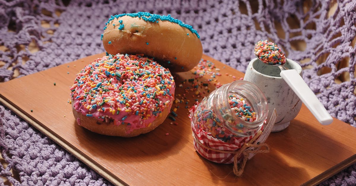 Is there a frosting similar to whipped cream but without cream? - Sweet doughnuts garnished with multicolored toppings placed on wooden board with jar of sweet sprinkles