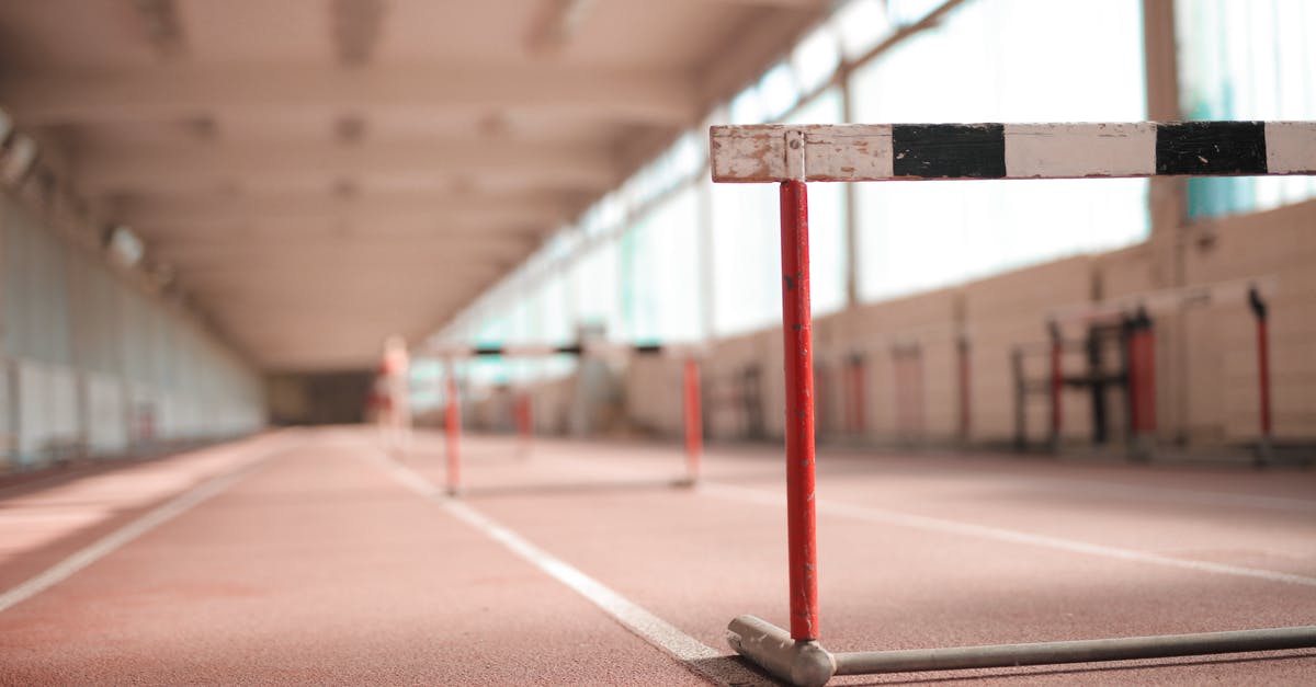 Is there a good, clean way to pit black olives? - Hurdle painted in white black and red colors placed on empty rubber running track in soft focus