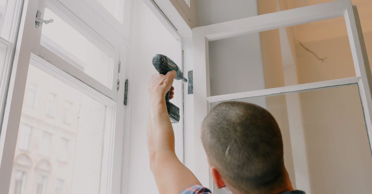 Is there a hand blender with a metal coupling connection? - Anonymous man installing window in room