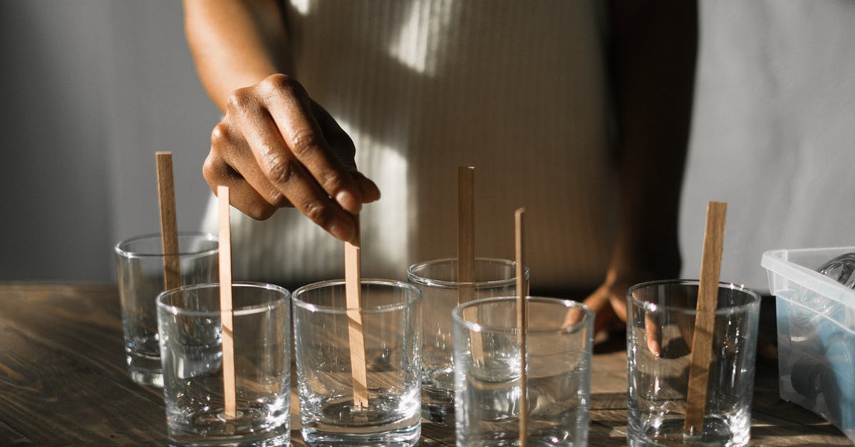 Is there a mold test kit for packaged food? - Unrecognizable African American female securing wooden wicks in glass molds while making aroma candles at wooden table in light studio