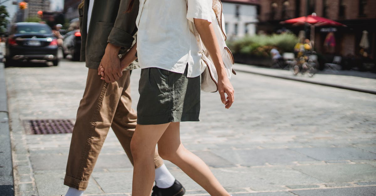 Is there a way to harden soft braised carrots? - Side view of unrecognizable couple holding hands and crossing road on sunny street in city with blurred cars and buildings