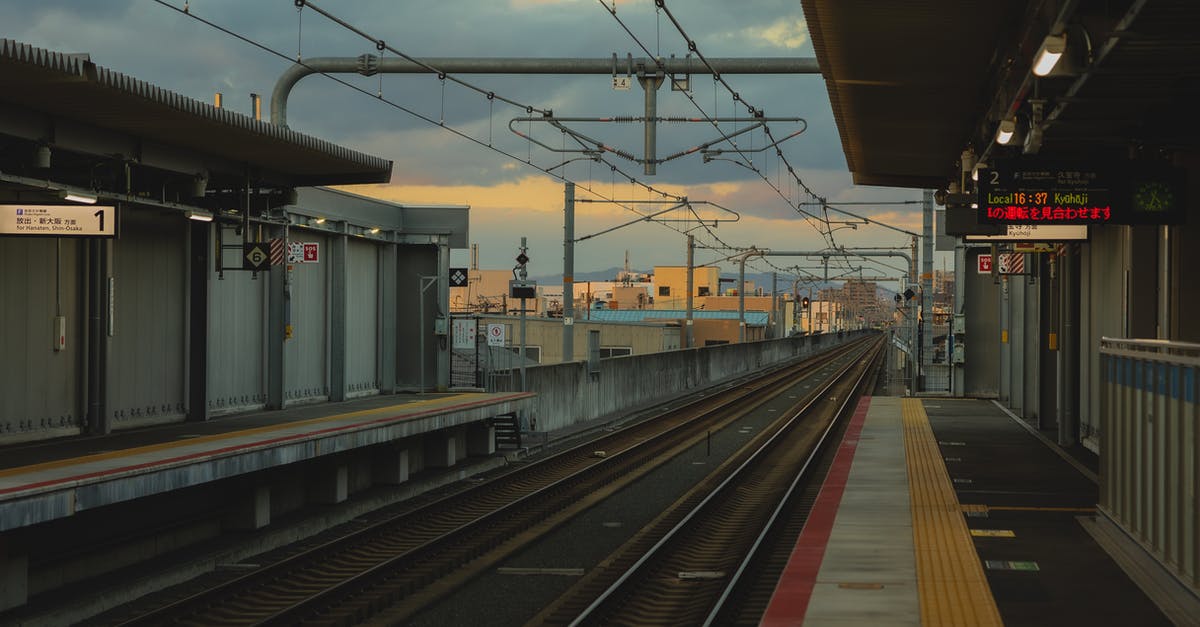 Is there a way to properly steel-cut oats yourself? - Railroad station with metal rails and glowing signboards on street in city with cables and buildings in distance on evening time