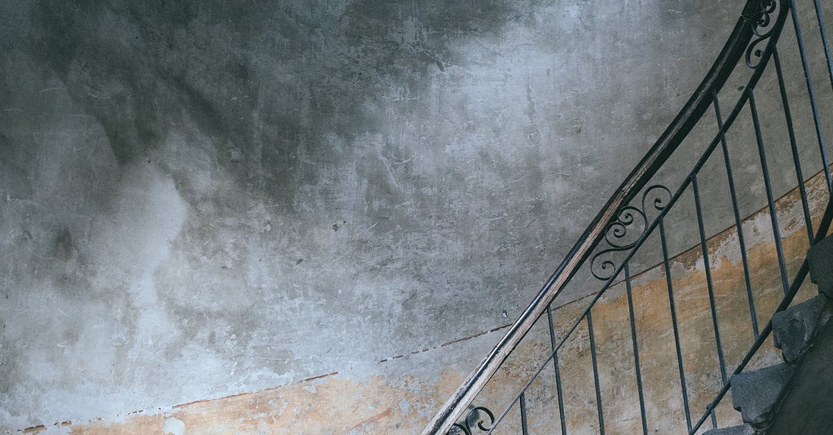 Is there any way to salvage an old rusted wok? - Stairway with metal railings and old shabby walls in porch of dwell building in city