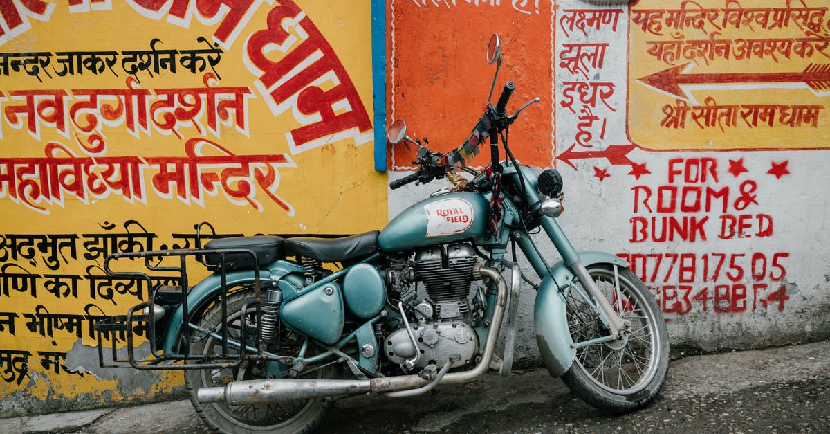 Is there any way to salvage an old rusted wok? - Old rusty motorcycle parked near shabby wall with various graffiti and inscriptions on city street