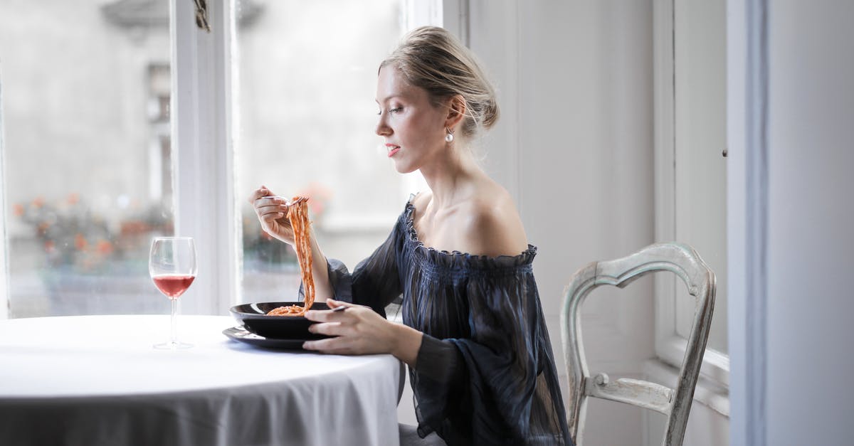 Is there grade/quality for spaghetti selection? - Selective Focus Photo of Woman in a Black Off Shoulder Dress Sitting at a Table Alone Eating Spaghetti 