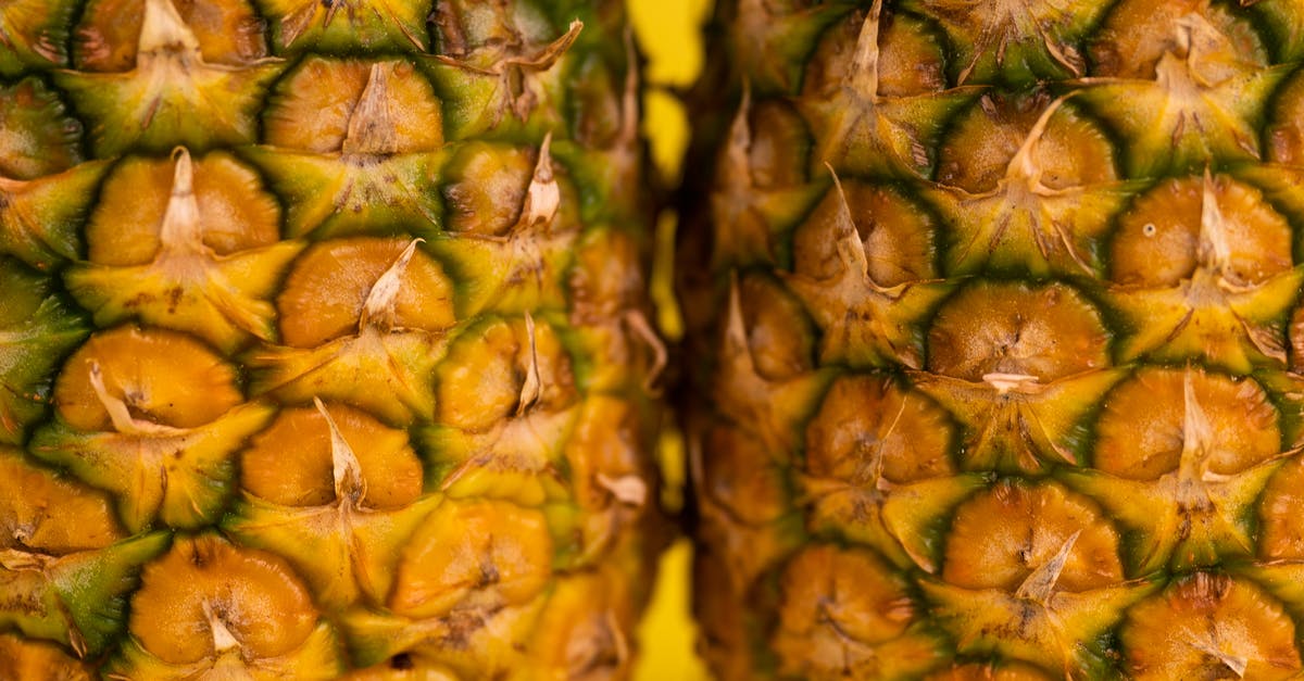 Is thick fruit skin safe to be eaten? [closed] - Closeup details of fresh whole pineapples with brown textured skin for healthy diet placed on yellow background in light studio