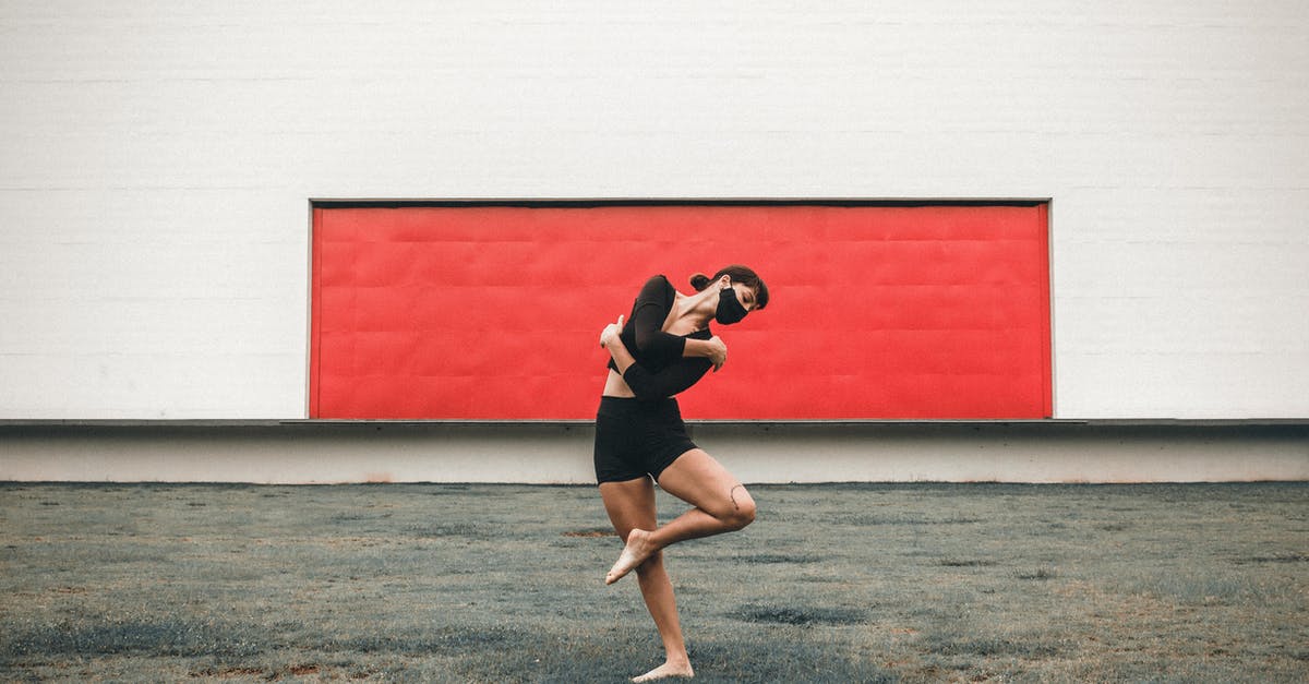 Is this ground beef safe to eat? - Full body of flexible barefoot female dancer wearing protective mask standing on one leg while performing dance movement on street