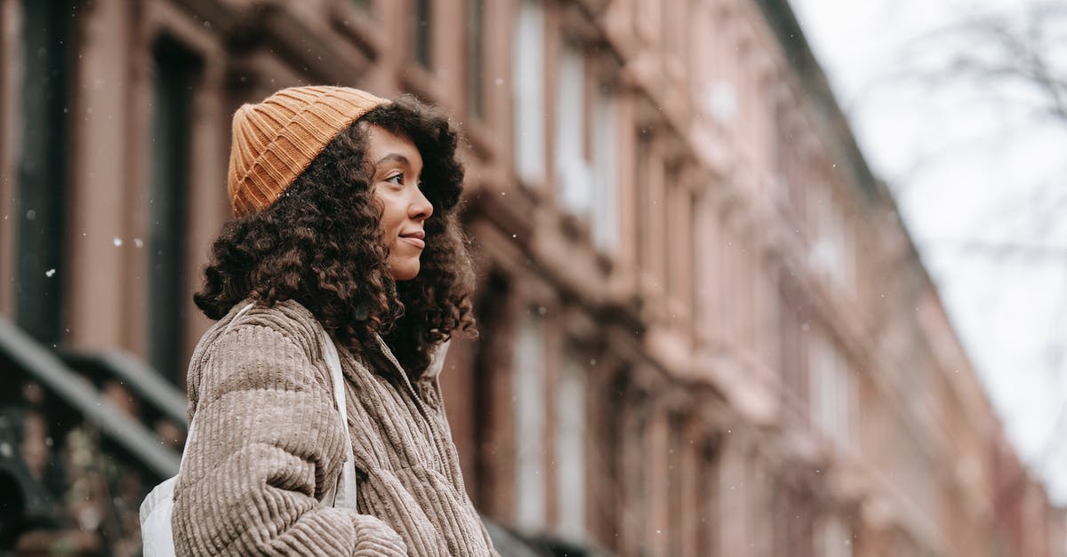 Is this some kind of warming oven? - Contemplative black woman on street in snowfall