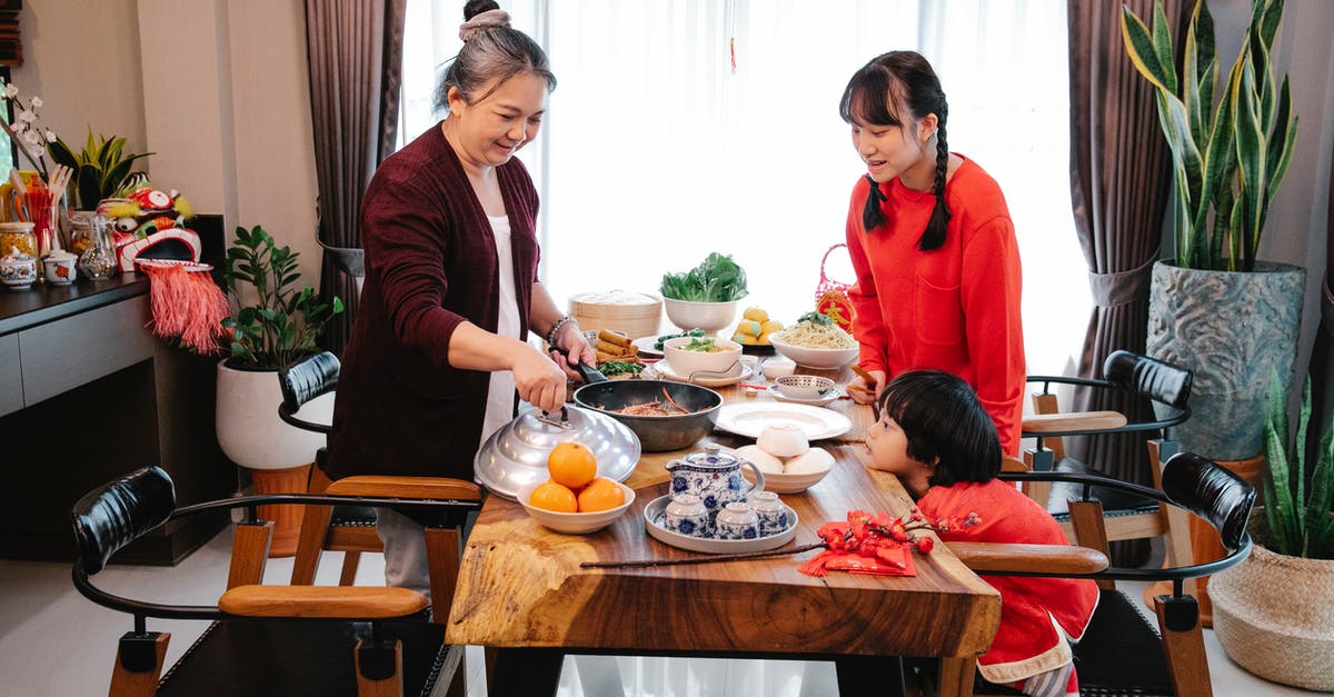 Is this wok nonstick? - Smiling Asian grandmother with teen and boy serving delicious food