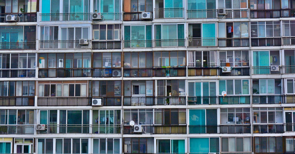 Is unnecessary refrigeration problematic? - Facade of contemporary residential multistage house with many apartments representing fenced terraces and windows near outdoor air conditioning units in town in daylight