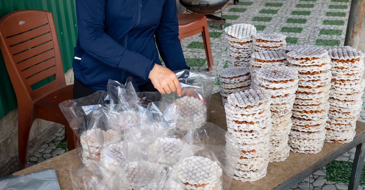 Is white rice bleached before being processed? - Crop vendor packing rice cakes at table