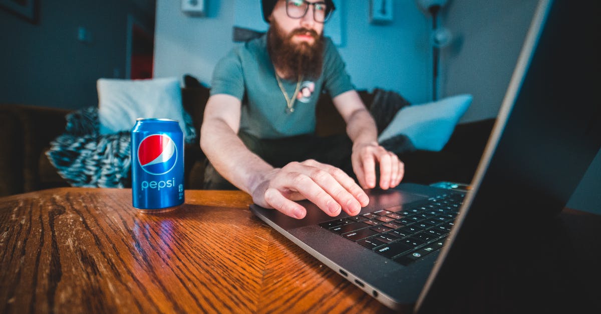 Israeli soda type drink - Man in Blue Polo Shirt Using Black Laptop Computer