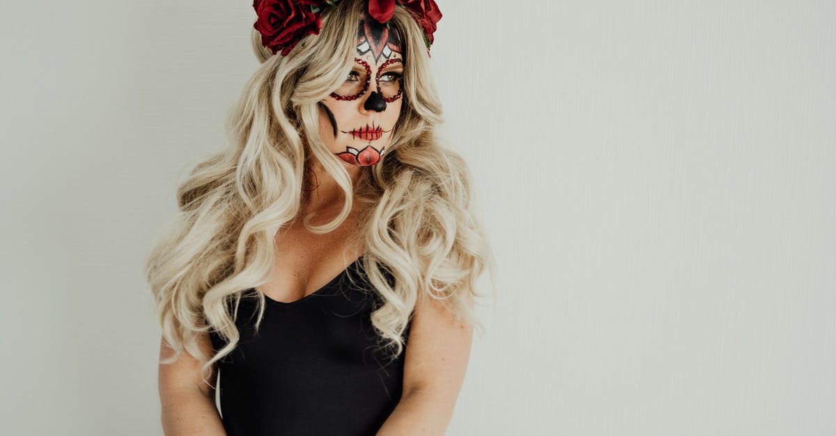 issues with mexican restaurant-style white cheesedip - Gorgeous young female with long blond hair in black dress with Mexican Catrina inspired makeup and floral headband standing against white background and looking away