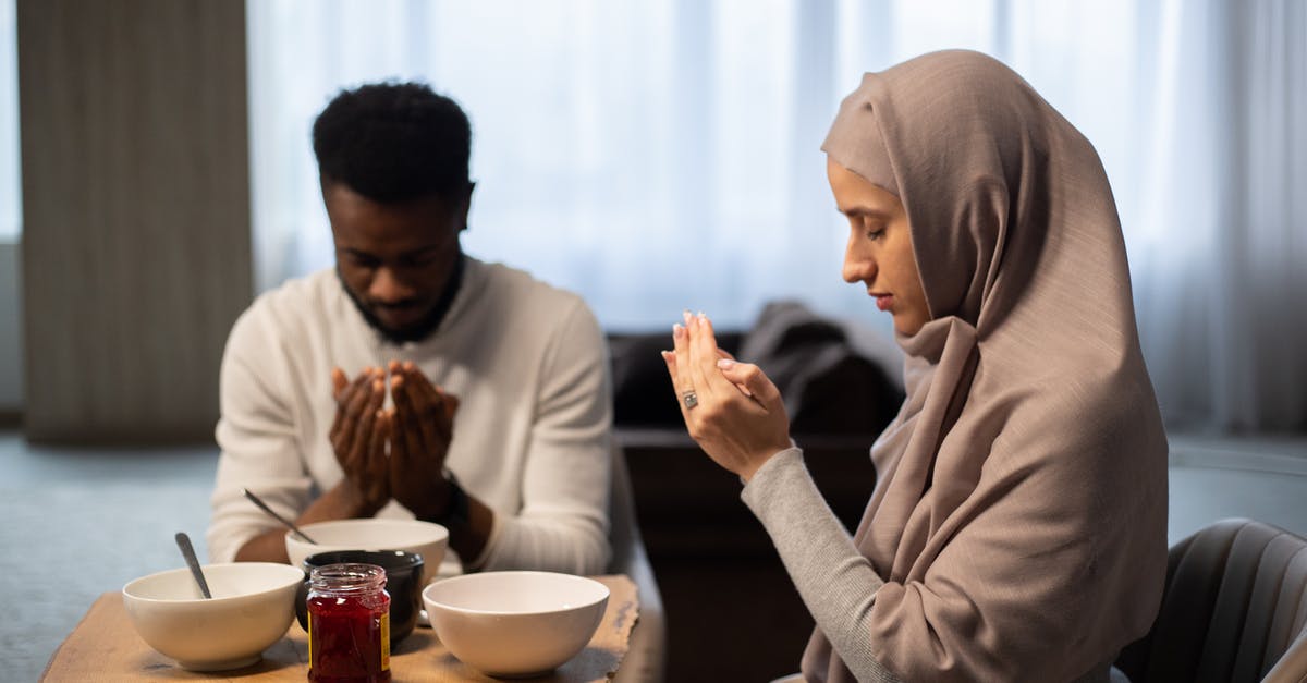 Jam scum after sealing - Multiethnic couple praying at table before eating