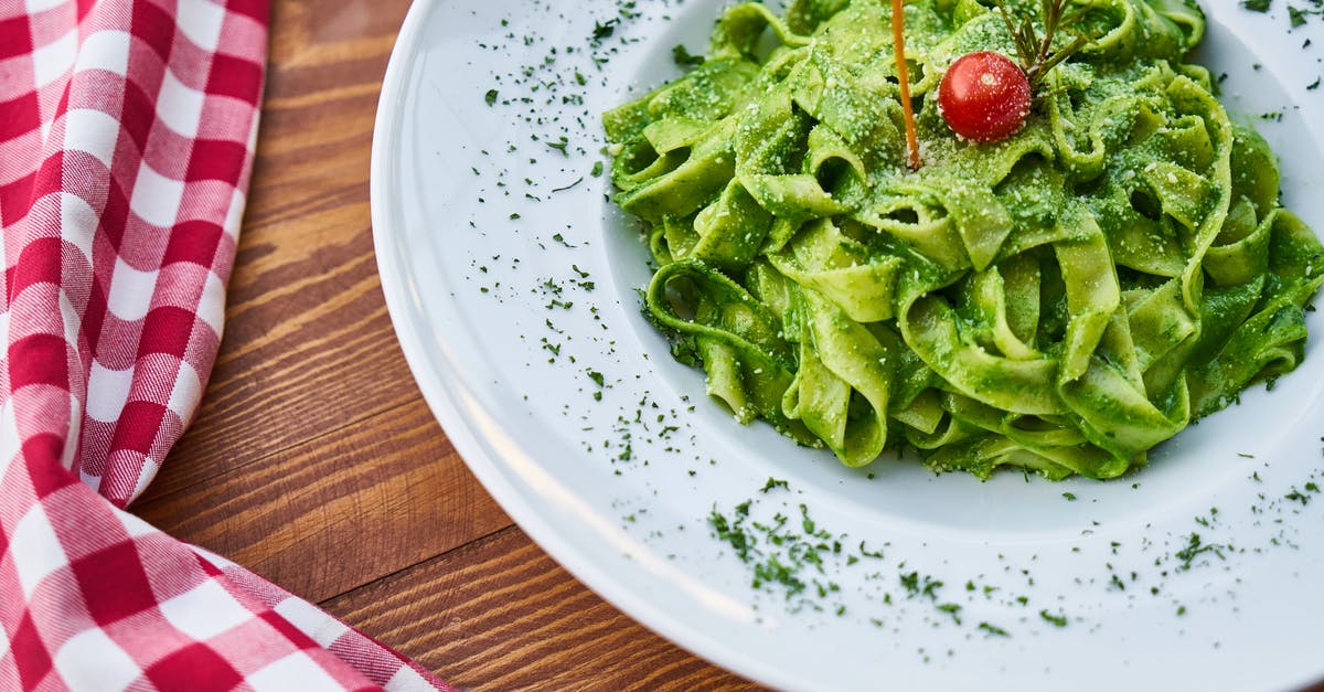 Keep fettuccine from sticking/clumping while cooking? - Flat Pasta Noodle With Green Sauce Dish and Cherry Tomato on Top