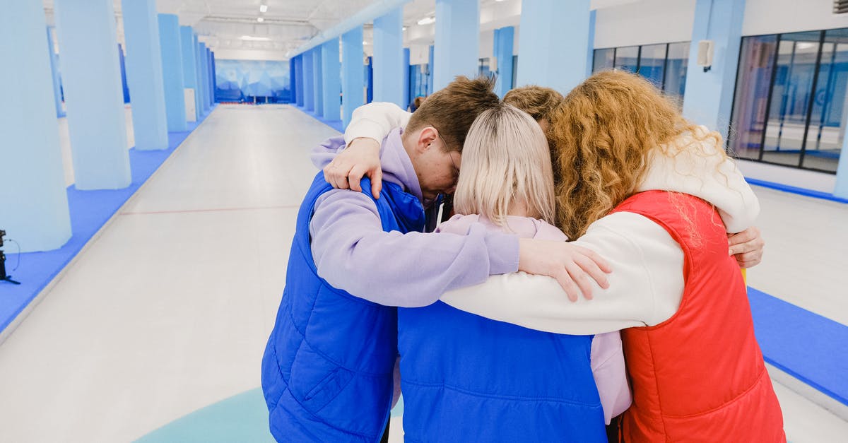 Keeping crushed ice from melting, without it joining back together - High angle of anonymous team embracing each other while standing in spacious light gym