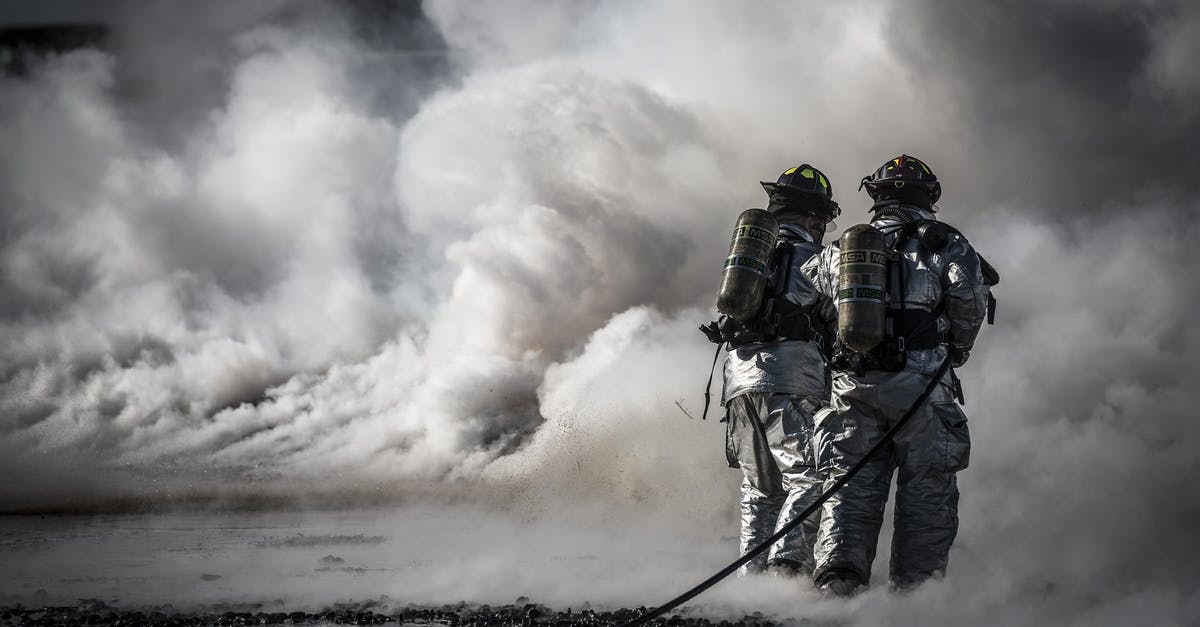 Keeping oil spray nozzle from clogging - Firefighter Standing Beside Smoke