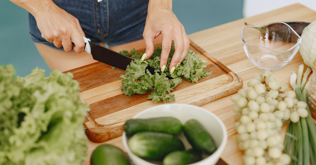 Kirby Cucumber Storage - Person Slicing Green Vegetable on Brown Wooden Chopping Board