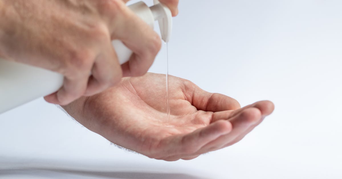 Knife cleaning: safe to do without soap? - Crop anonymous male pouring antibacterial soap sanitizer for preventing spread of diseases and avoid infections