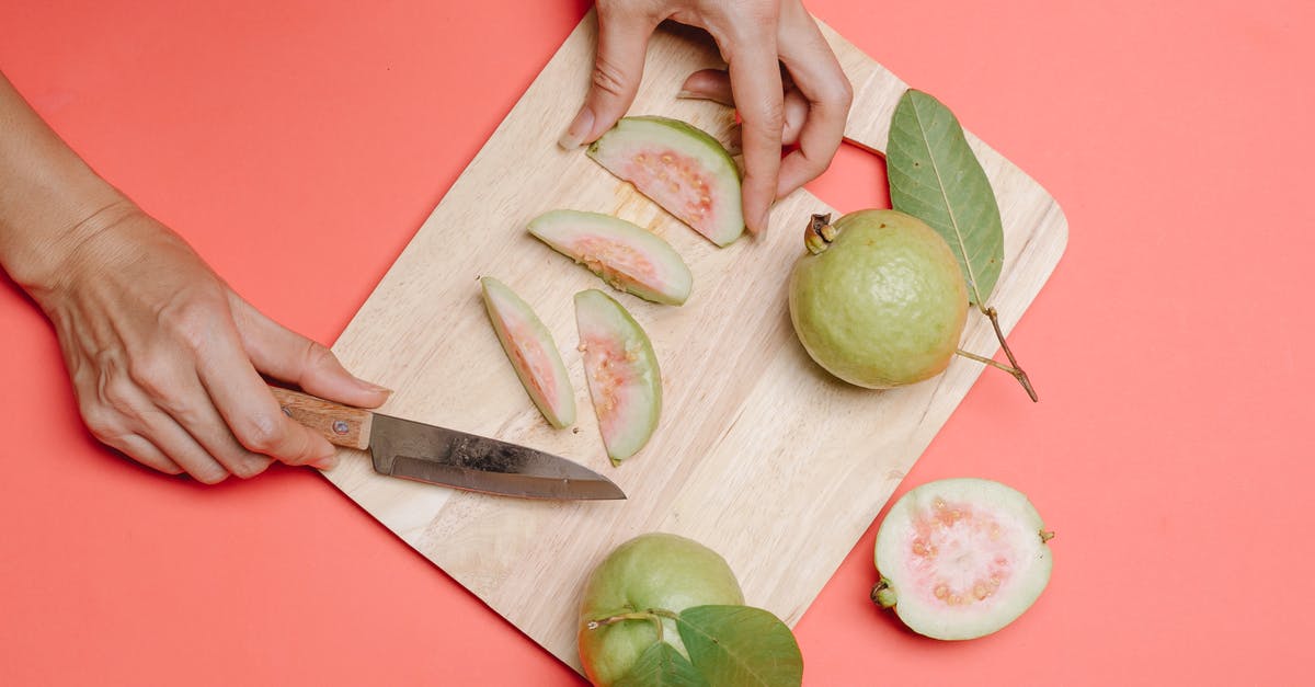 Knife for cutting steak slices from whole ribeye? - Crop person cutting guava on board