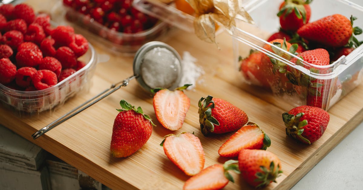 Lamb half cook then recook next day - Halves and whole strawberries with raspberries and physalis in plastic containers placed on wooden board