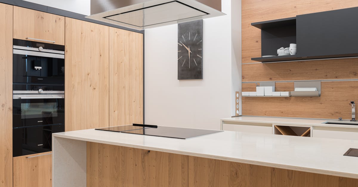 Leaving empty cast iron pot on a gas stove - Contemporary kitchen with black clock and cupboard with white utensil