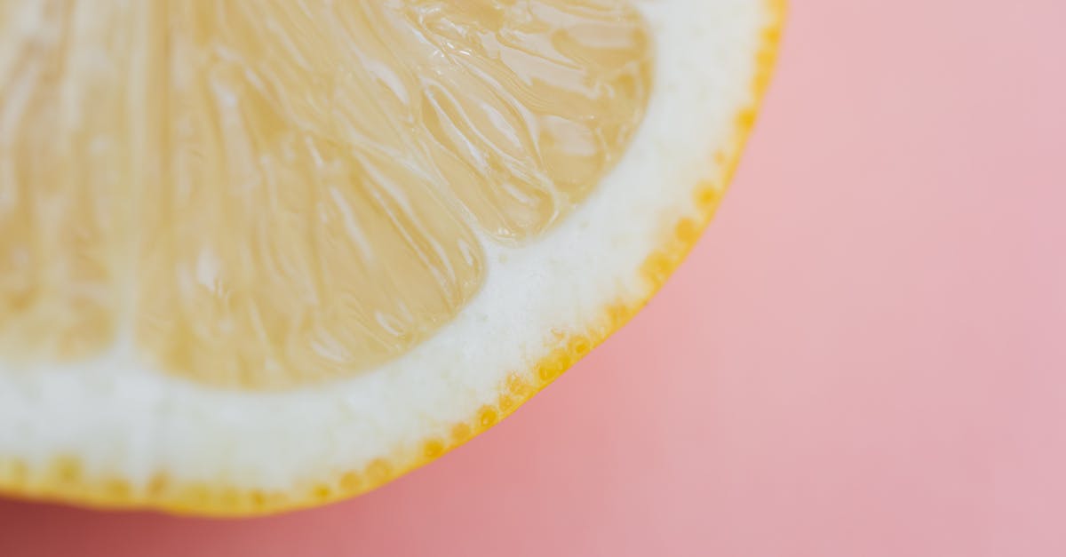 Lemon juice as a natural preservative for soups - Fresh sliced lemon on pink background