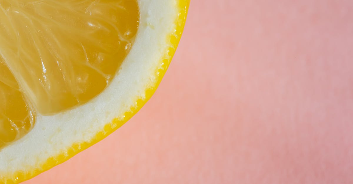 Lemon juice as a natural preservative for soups - Quarter of lemon on pink background