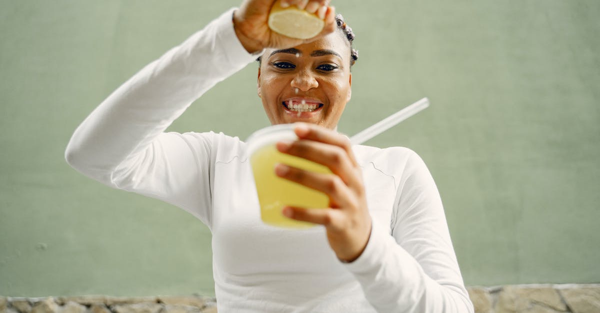 lemon juice curdling white chocolate - A Woman Squeezing a Lemon Into a Plastic Cup