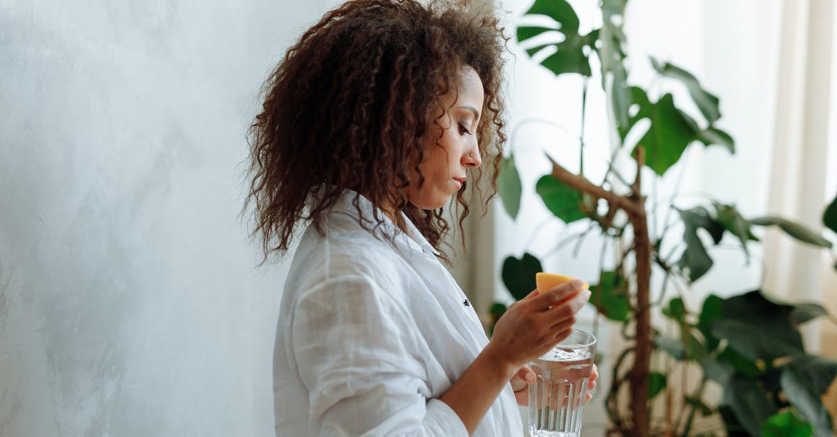 Lemon liqueur has gas? - Woman in White Long Sleeve Shirt Holding Drinking Glass