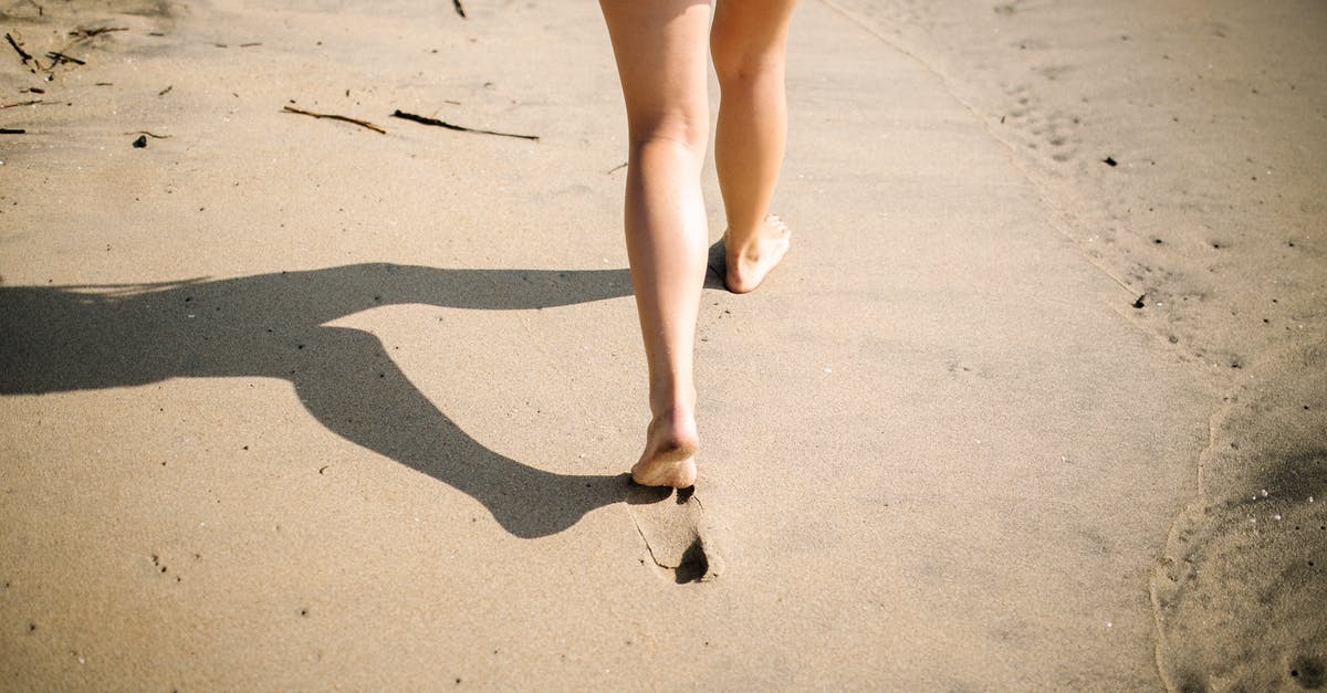 lids popped loudly second day - Woman in Blue Denim Shorts Walking on White Sand