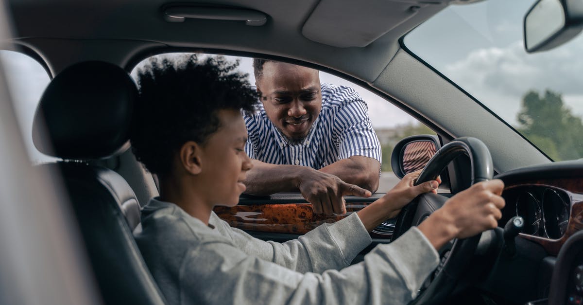 lids popped loudly second day - Man in Blue and White Striped Dress Shirt Sitting on Car Seat