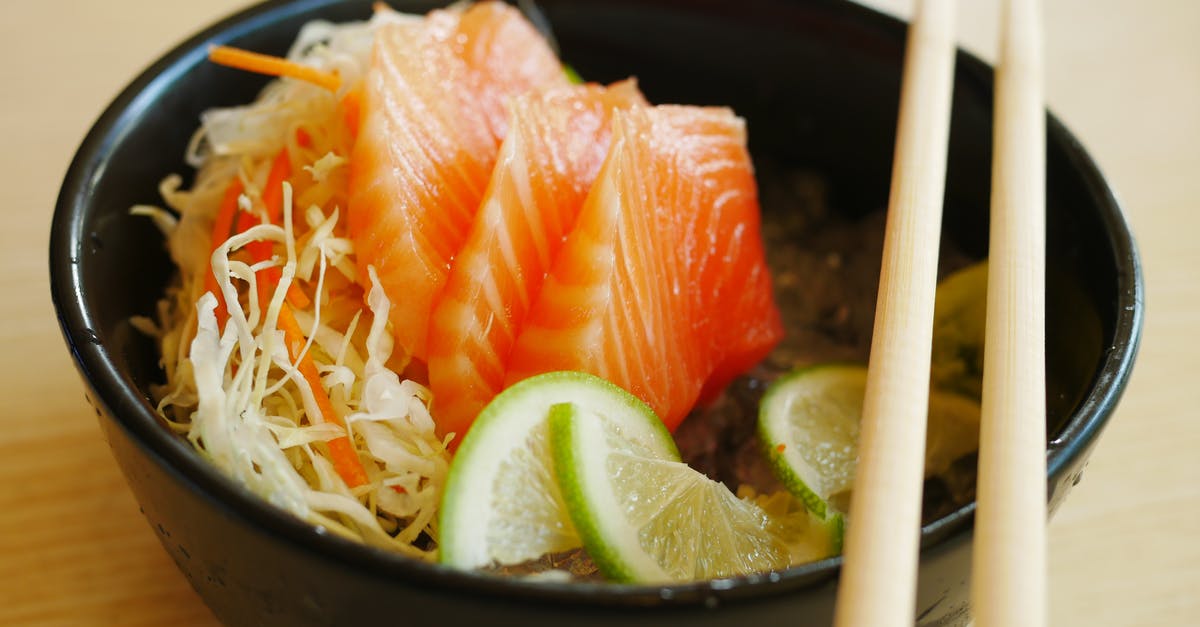 Lime on Fish tastes Bitter - Slices of Salmon Sashimi with Slices of Lime on Black Bowl