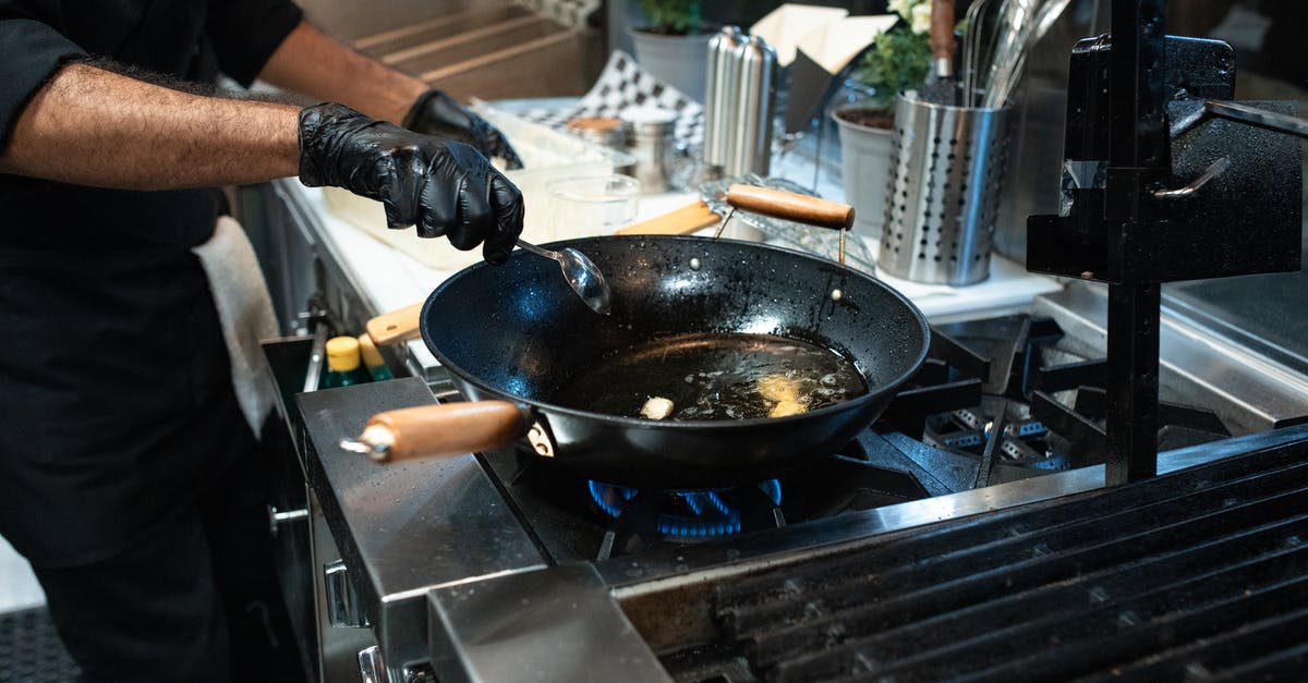Lining a frying pan with aluminum foil to reduce post-cooking cleanup? - Person Cooking on Black Pan