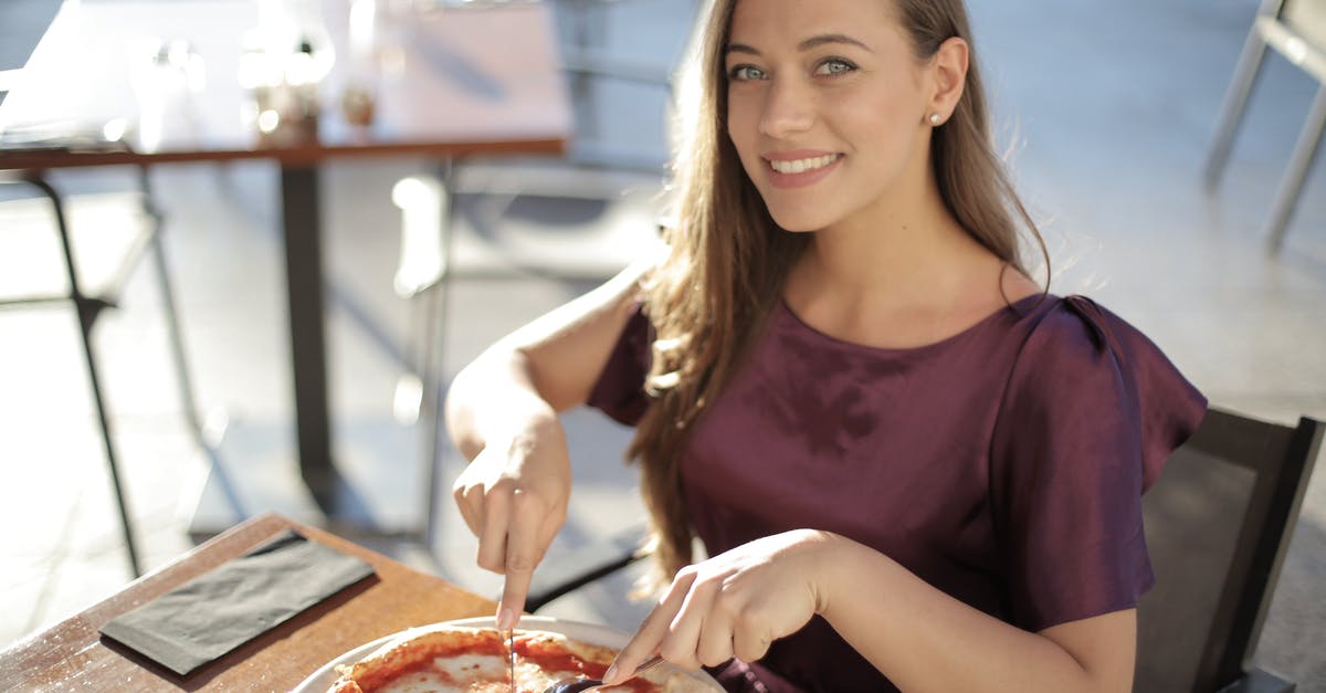 Looking for an accurate nutrition database - Woman in Purple Top Eating Pizza