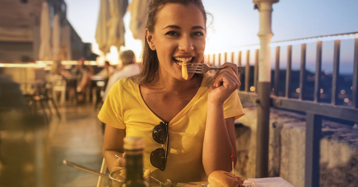 Looking for the name of a Peruvian dish - Woman in Yellow Crew Neck T-shirt Eating Burger